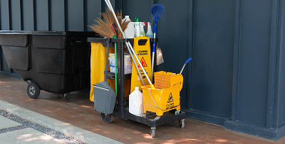 jornitorial card with full cleaning equipment park beside